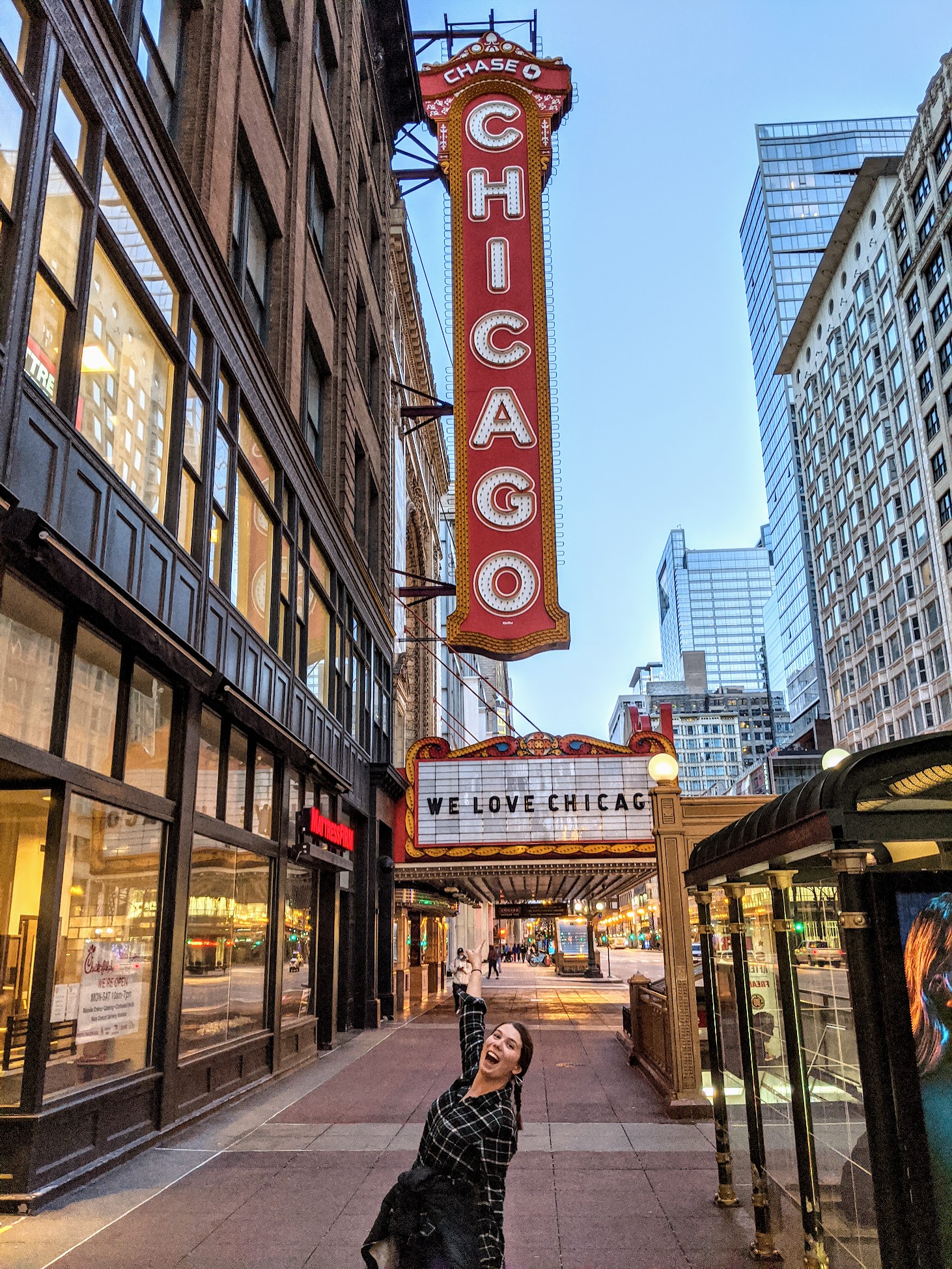 Annie pointing a the Chicago Theater sign